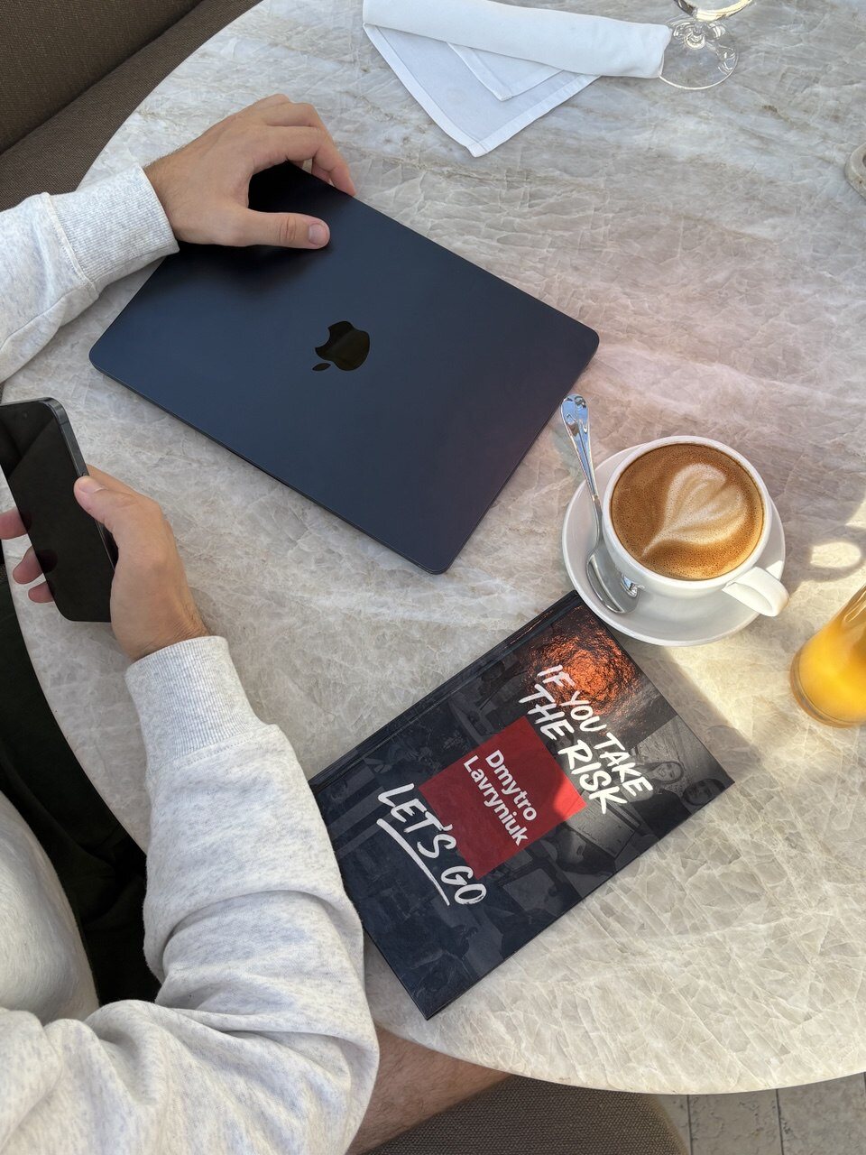 The book on a cafe table with a laptop and coffee